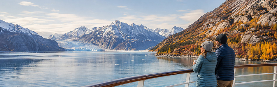 Couple enjoying breathtaking glacier views from an Alaska cruise ship during the best time to visit Alaska.
