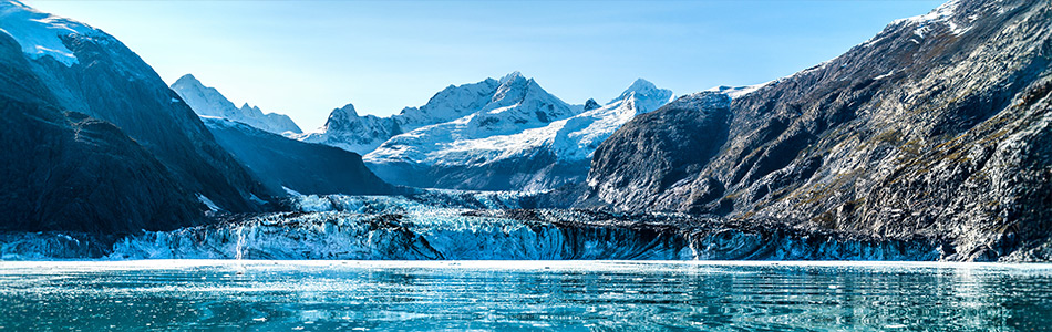 Johns Hopkins Glacier rises above the icy waters and rugged mountains of Glacier Bay National Park in Alaska.