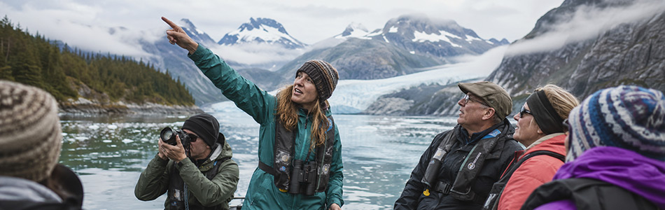 Expedition guide leads guests through an Alaska glacier landscape during a small-ship excursion.