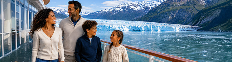 Family aboard an Alaska cruise admiring a massive glacier and snow-capped mountains from the ship's outdoor deck.