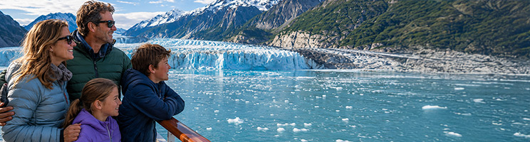 Family enjoying glacier viewing from the deck of an Alaska cruise ship surrounded by snow-capped mountains and icy waters.