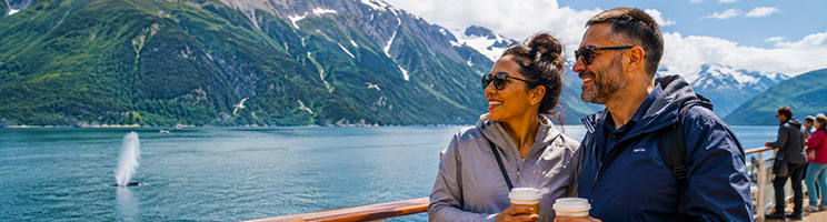 Couple spotting wildlife on an Alaska cruise during the best time to visit Alaska. Couple spotting wildlife on an Alaska cruise during the best time to visit Alaska.